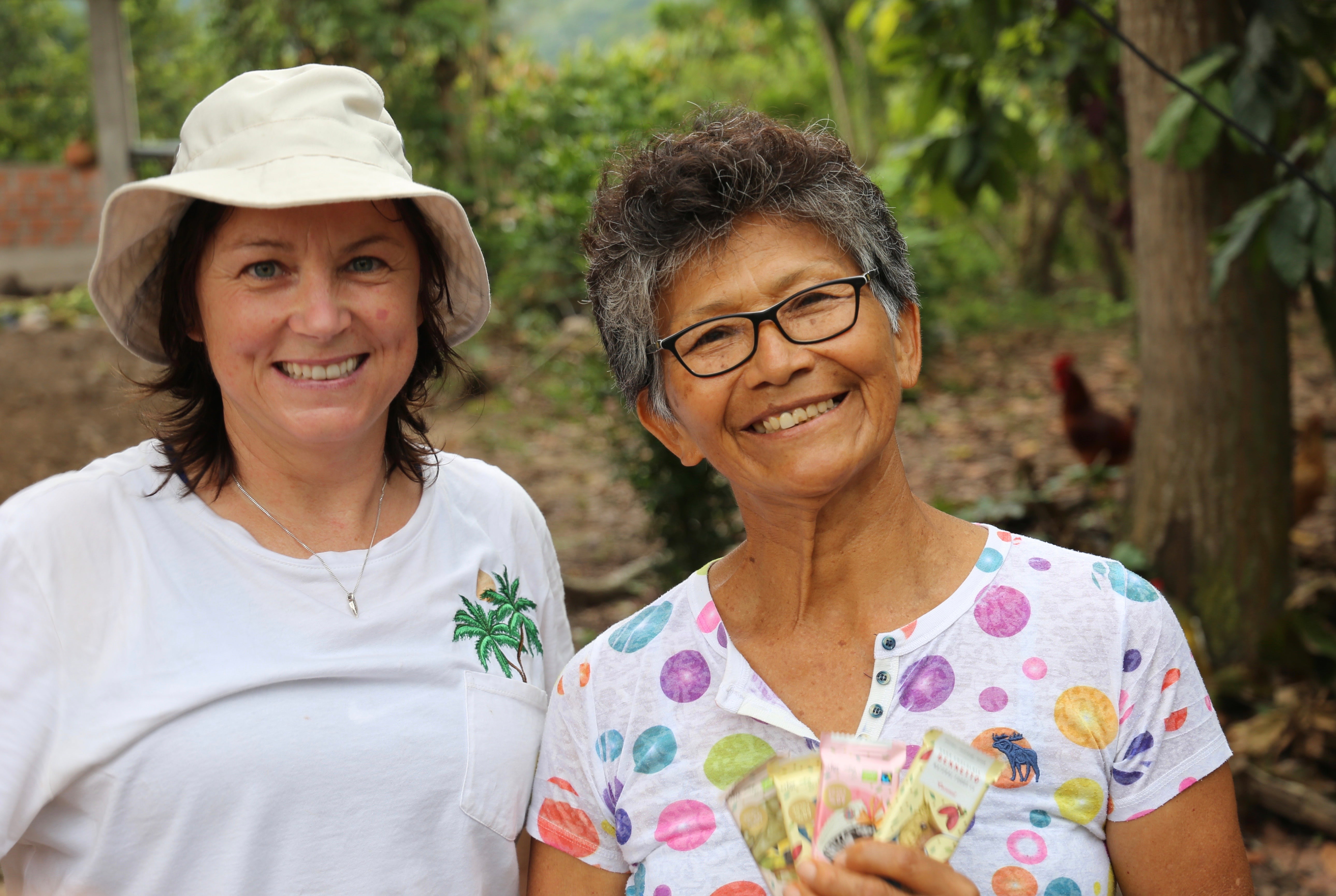 image of founder (Lucy), left, with Bennetto cocoa grower on right when visiting plantations of where we source our cocoa in South America.