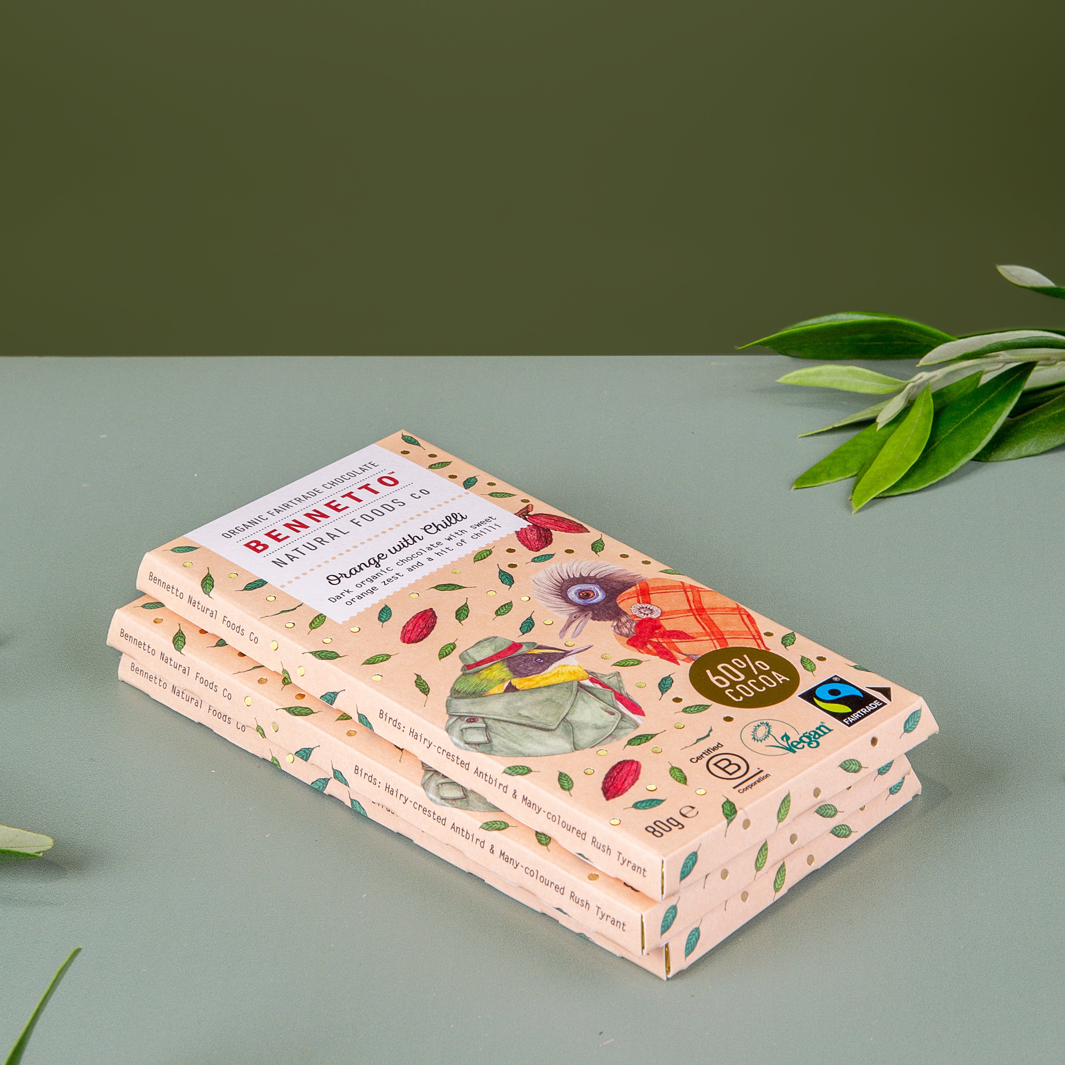 Stack of 3 Bennetto Orange with Chilli organic and vegan dark chocolate bars on a green background 